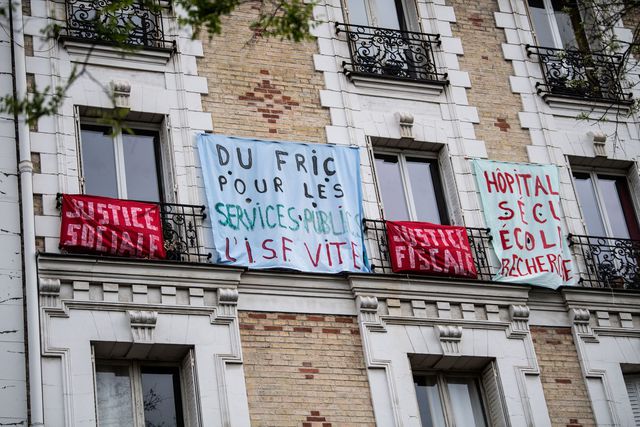 Une banderole "Du fric pour les services publics" accrochée à un balcon parisien, le 1er mai 2020.