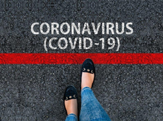 Pieds devant une ligne rouge tracé au sol Coronavirus