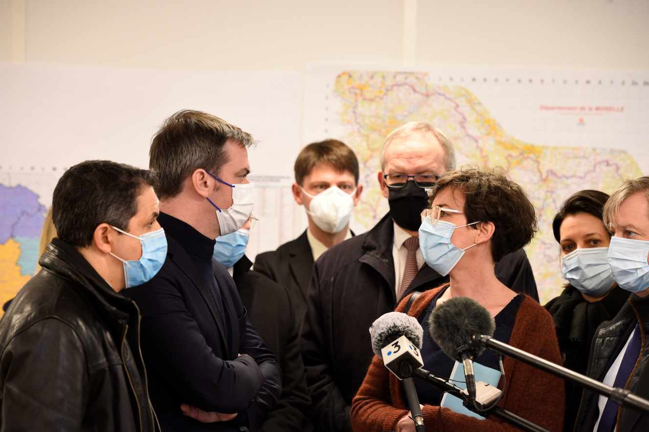 Le ministre de la santé, Olivier Véran, aux côtés du député du département Belkhir Belhaddad (à gauche), discute avec Véronique Cayre, directrice de l’ARS de la région Grand-Est, et François Grosdidier, maire LR de Metz, le 12 février 2021.
