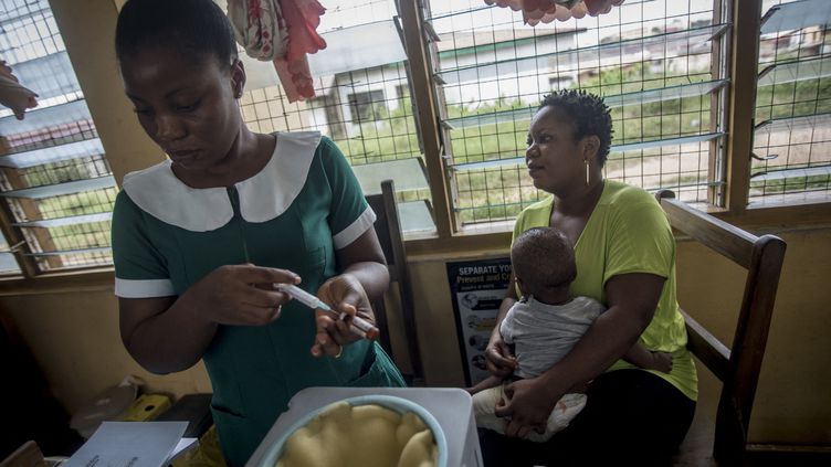 Une infirmière prend un vaccin contre la fièvre jaune pour l'administrer à un enfant au Ghana, le 30 avril 2019. Photo d'illustration. (CRISTINA ALDEHUELA / AFP)