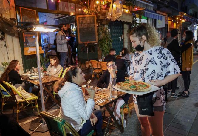 Des gens déjeunent dans un restaurant de la ville côtière israélienne de Tel-Aviv, le 7 mars.