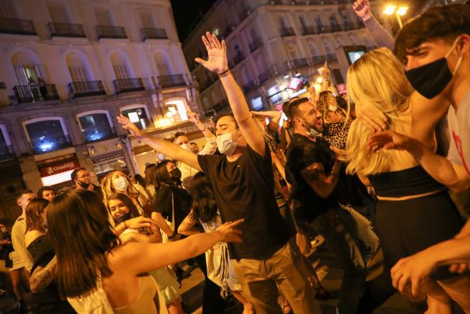 Des habitants célèbrent la fin de l’état d’urgence sur la place de Puerta del Sol à Madrid, dans la nuit de samedi 8 à dimanche 9 mai.